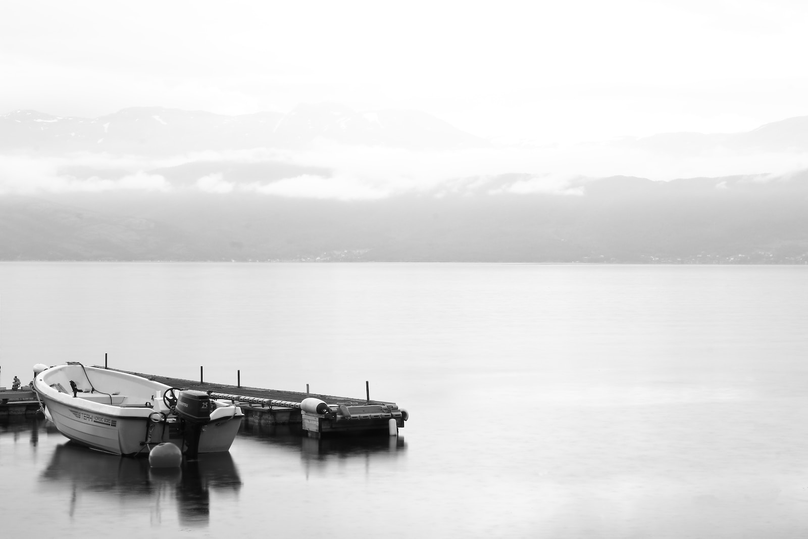 grayscale photo of 2 boats on lake